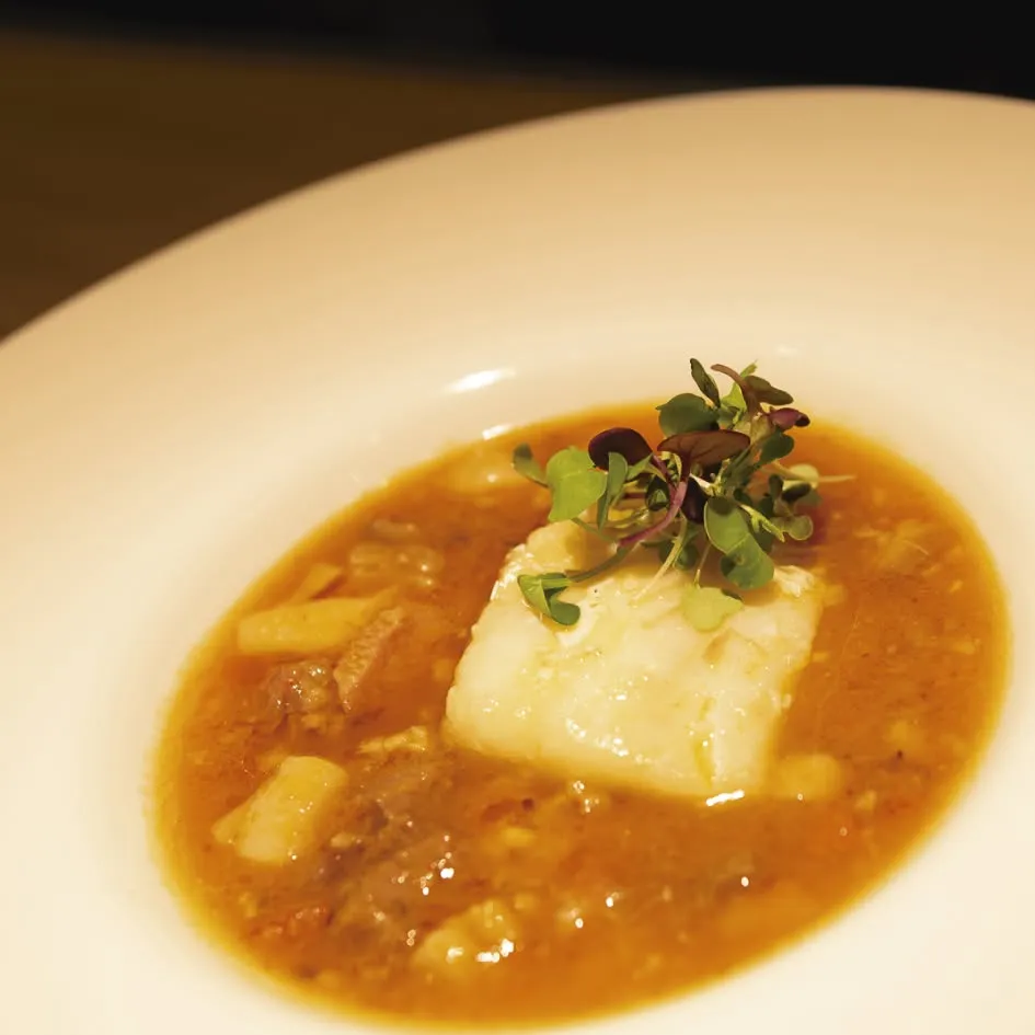 Plat fondo amb peix blanc en suc, acabat de servir